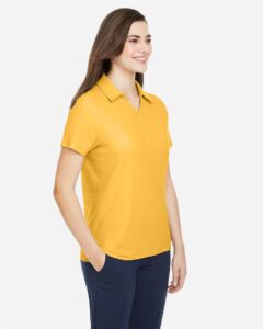 CORE365 CE112W Women’s Fusion ChromaSoft™ Pique Polo – Campus Gold (on model side)
