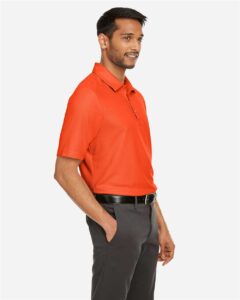 CORE365 CE112 Men’s Fusion ChromaSoft™ Pique Polo – Campus Orange (on model side)