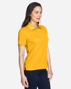 CORE365 78181 Women’s Origin Performance Piqué Polo – Campus Gold (on model side)