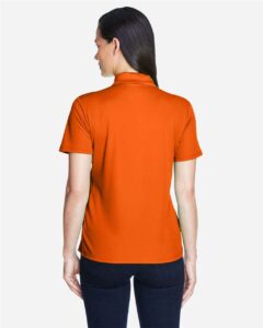 CORE365 78181 Women’s Origin Performance Piqué Polo – Campus Orange (on model back)