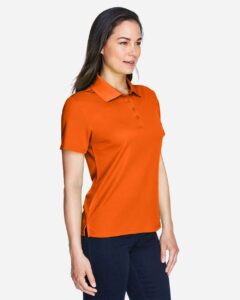 CORE365 78181 Women’s Origin Performance Piqué Polo – Campus Orange (on model side)