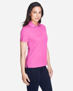 CORE365 78181 Women’s Origin Performance Piqué Polo – Charity Pink (on model side)