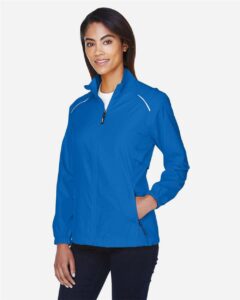 CORE365 78183 Women’s Techno Lite Motivate Unlined Lightweight Jacket – True Royal (on model side)