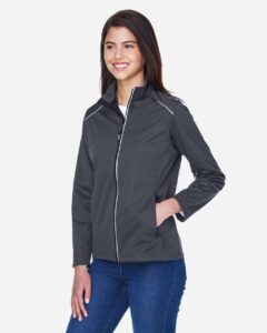 CORE365 CE708W Women’s Techno Lite Three-Layer Knit Tech-Shell – Carbon (on model side)