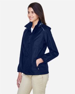 CORE365 78185 Women’s Climate Seam-Sealed Lightweight Variegated Ripstop Jacket – Classic Navy (on model side)