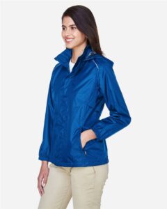 CORE365 78185 Women’s Climate Seam-Sealed Lightweight Variegated Ripstop Jacket – True Royal (on model side)