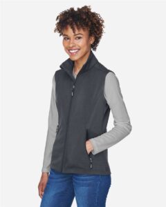 CORE365 CE701W Women’s Cruise Two-Layer Fleece Bonded Soft Shell Vest – Carbon (on model side)