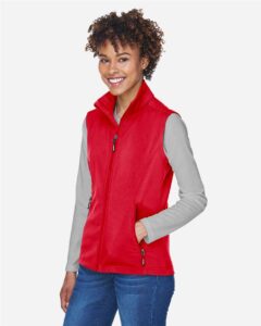 CORE365 CE701W Women’s Cruise Two-Layer Fleece Bonded Soft Shell Vest – Classic Red (on model side)
