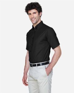 CORE365 88194T Men’s Tall Optimum Short Sleeve Twill Dress Shirt – Black (on model side)