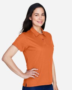 Team 365 TT21W Women’s Command Snag Protection Polo – Sport Burnt Orange (on model side)