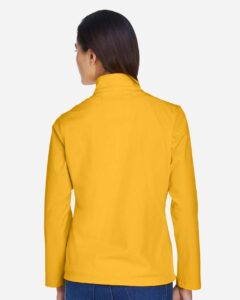 Team 365 TT80W Women’s Leader Soft Shell Jacket – Sport Athletic Gold (on model back)