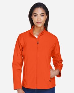 Team 365 TT80W Women’s Leader Soft Shell Jacket – Sport Orange (on model)