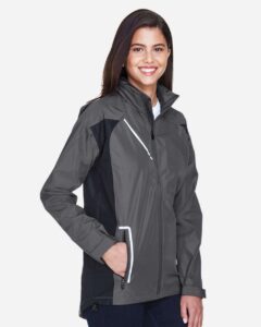 Team 365 TT86W Women’s Dominator Waterproof Jacket – Sport Graphite (on model side)
