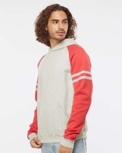 JERZEES 97CR Unisex Nublend® Varsity Colorblocked Raglan Hooded Sweatshirt – Oatmeal Heather/ Fiery Red Heather (on model side)